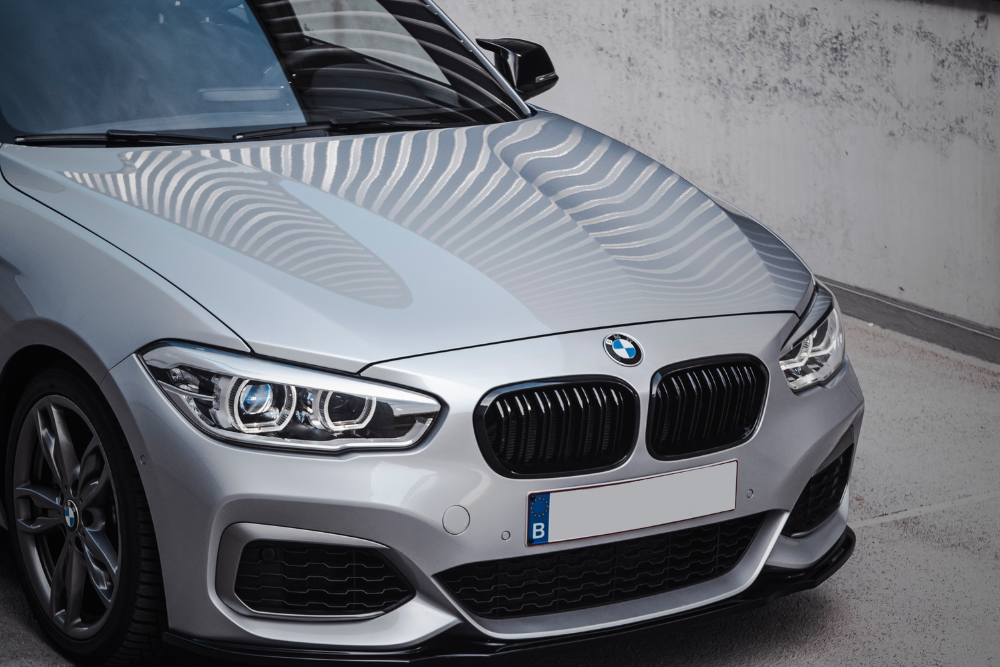 European vehicle car care in Vacaville, CA at Motoring Specialists. A silver BMW car parked outdoors, showing the front grille, headlights, and hood.