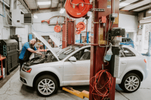 Car maintenance, auto repair in Vacaville, CA by Motoring Specialists. Image of a technician servicing a European sedan inside a professional repair facility, highlighting precise diagnostics, preventative maintenance, and dependable import vehicle care.